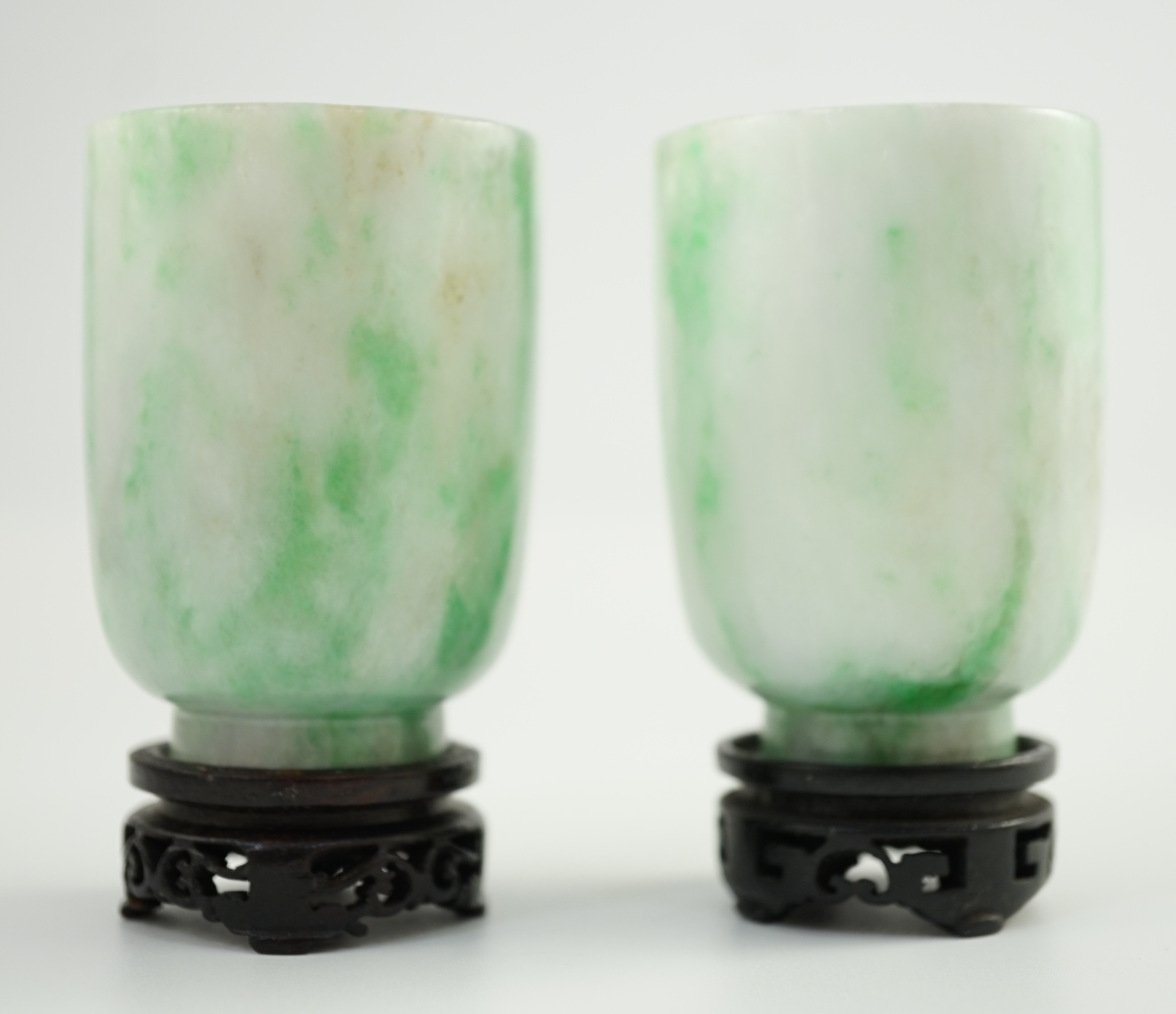 A pair of Chinese jadeite cups, 6.2cm high, wood stands, fitted box